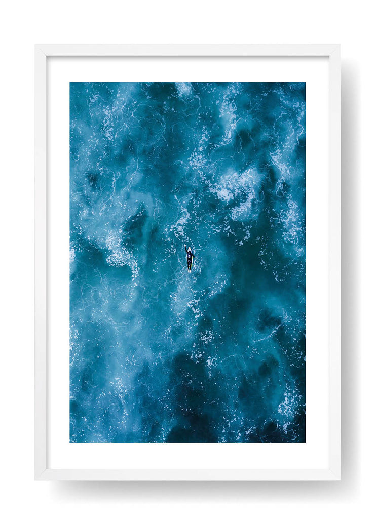 Surfeur pagayant dans la mer bleue
