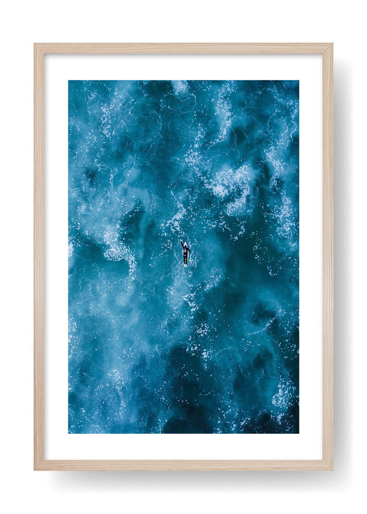 Surfeur pagayant dans la mer bleue